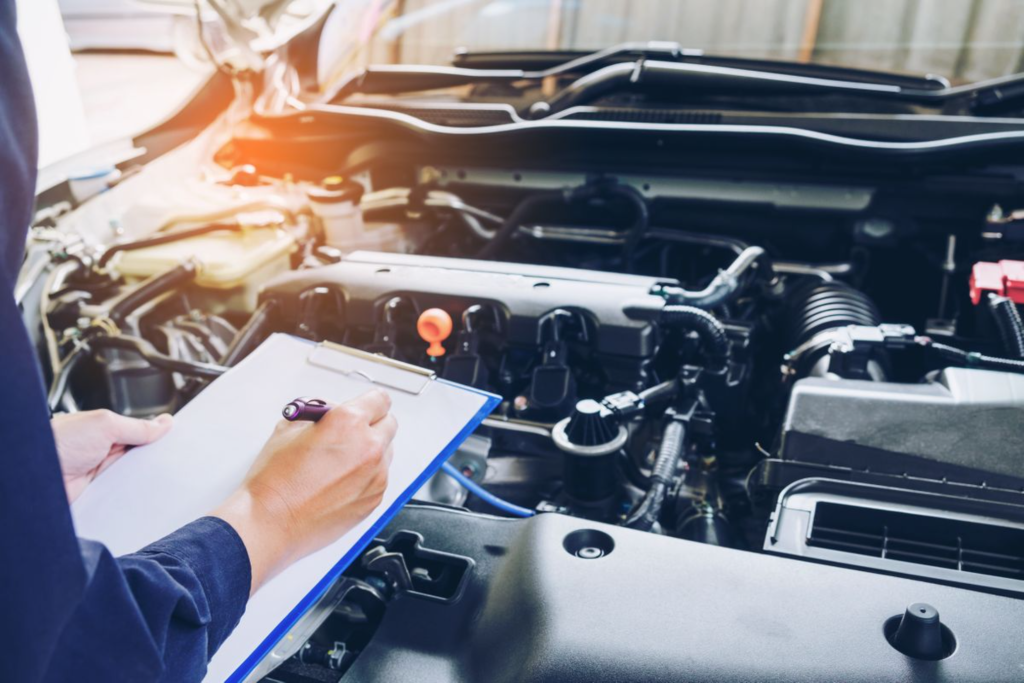 Mechanic inspecting vehicle maintenance or diagnostic check in a workshop.