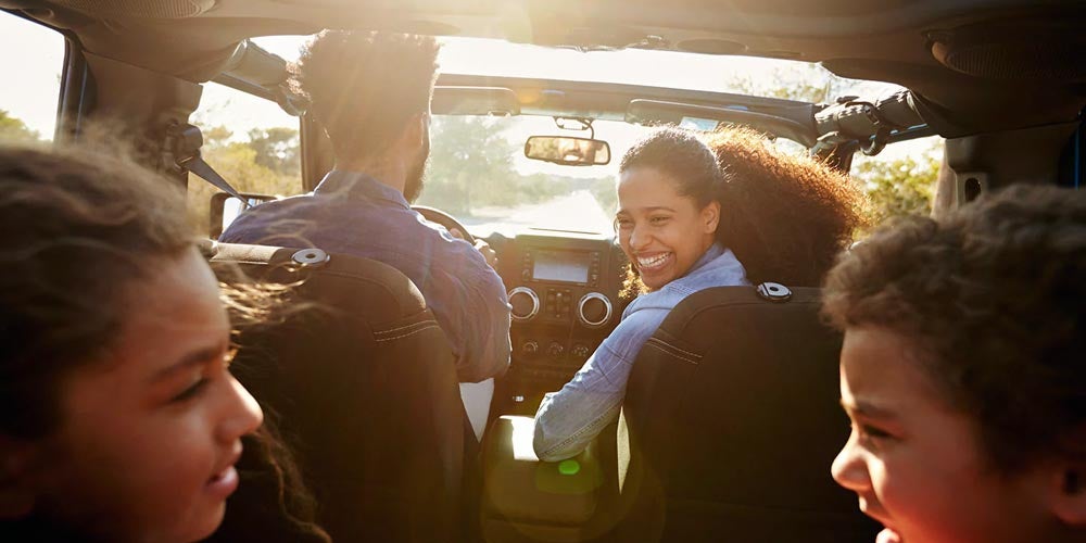 Smiling family driving inside vehicle
