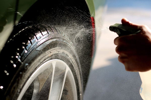 spraying tire with cleaner